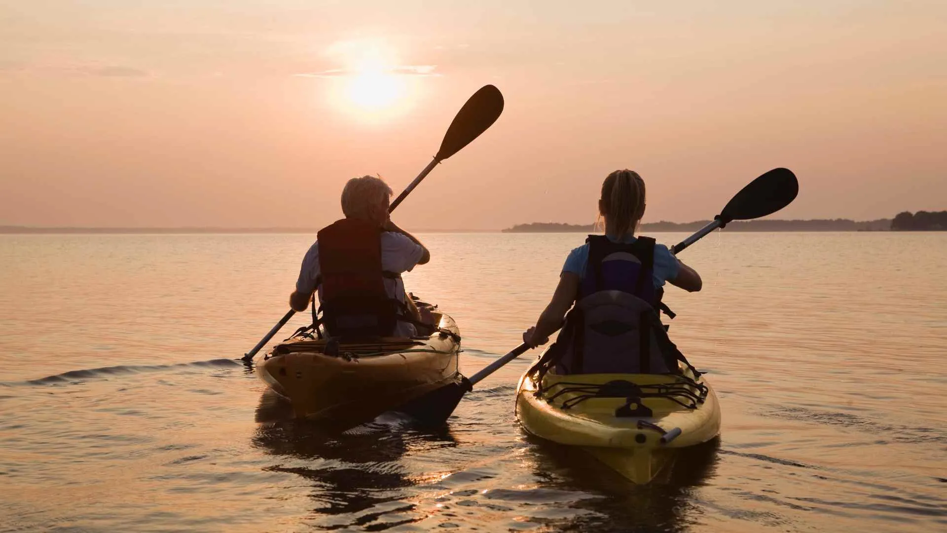 2 friends kayaking into sunset 2 friends kayaking into sunset